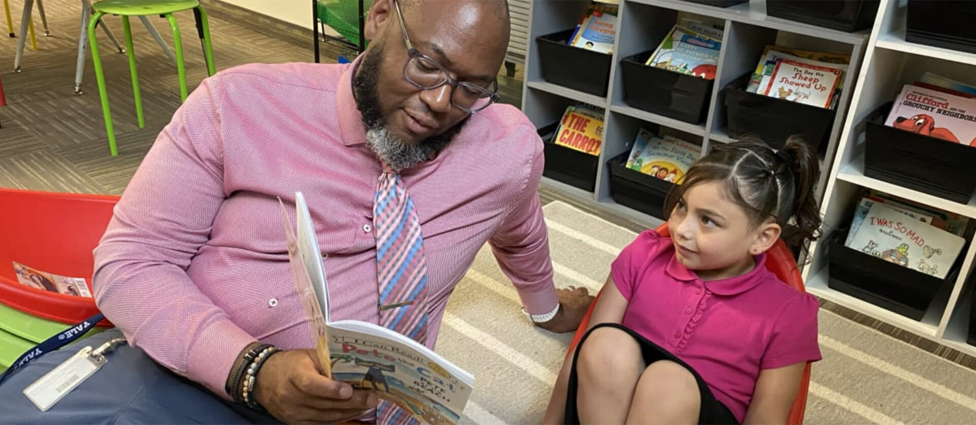 Teacher reading a book to a young student
